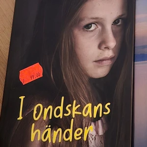 I ondskans händer - Boken 'I ondskans händer' har en omslagsbild med en ung flicka som ser allvarlig ut. Priset är markerat med en röd etikett. Titeln är skriven i gul text.