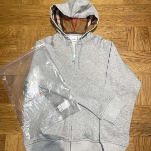  Burberry kofta - Säljer en grå kofta från Burberry. Perfekt för en avslappnad och trendig look. Helt nytt, oanvänt