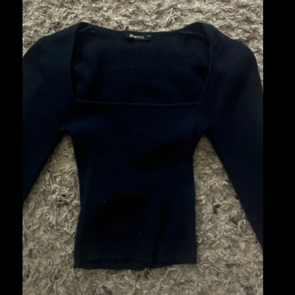 Snygg svart topp från Bik Bok med lång ärm och fyrkantig halsringning. Perfekt för en stilren look. Passar bra till både jeans och kjol.. Neuletakit & Villapaidat.