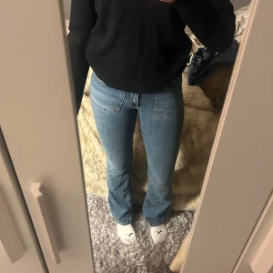 Blå bootcut jeans från Nelly  - Snygga blå bootcut jeans med låg midja. Perfekta för en avslappnad stil. Klassisk design med fem fickor och knappgylf.