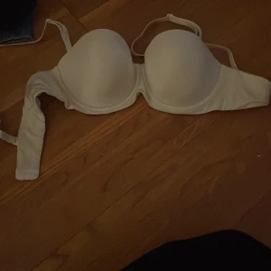 Vit bh från Lindex - Säljer en vit bh från Lindex i storlek 80A. Den har en enkel och stilren design med justerbara axelband och hakknäppning bak. Perfekt för vardagsbruk.