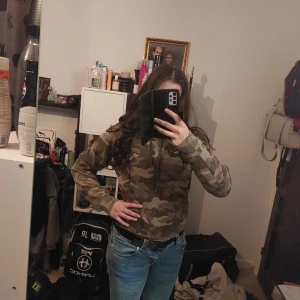 Camouflage hoodie - Säljer en cool camouflage hoodie med huva och långa ärmar. Perfekt för en avslappnad stil. Passar bra till jeans eller andra casual outfits.