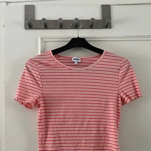 Randig ribbad topp från Bubbleroom - Säljer en söt randig topp från Bubbleroom i rött och vitt. Toppen är ribbad med korta ärmar och har en fin vågig kant nedtill. Perfekt för en avslappnad stil. Aldrig använd