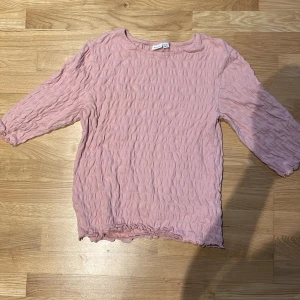 Rosa topp  - Säljer en rosa tröja/topp med trekvarts ärmar i storlek 158-164 (13-14år). Passar XS