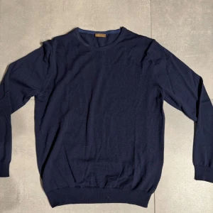 Mörkblå tröja från Stenströms merinoull  - Snygg och stilren mörkblå tröja från Stenströms. Perfekt för en klassisk look med rund hals och ribbade kanter. Passar utmärkt till både vardag och mer uppklädda tillfällen. Tröjan är i merinoull och i nyskick! Ny pris 2000kr mitt pris 499kr! Hör av er vid fler frågor eller bilder!