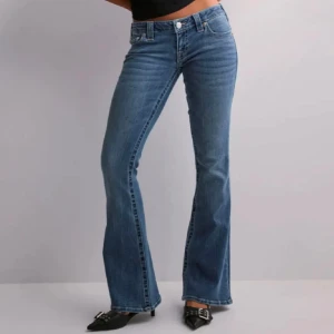 Blå bootcut jeans från True Religion - PRIS GÅR ATT DISKUTERA 💗Snygga blå super lowwaist bootcut jeans från True Religion med klassisk femficksdesign och märkets ikoniska logga på bakfickan. Perfekta för en avslappnad stil med en touch av retro. Aldrig använda och köpta på Nelly i deras collab med true religion, nypris 1400. Storlek W25 och passar mig som brukar ha W26, 34, 36 i jeans