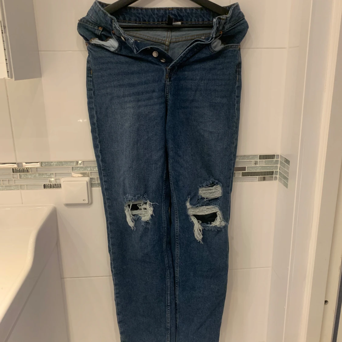 Blå jeans med slitningar