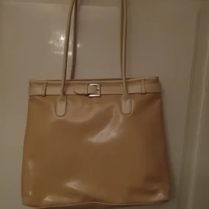 Beige axelväska från Sacatini - Snygg stor beige axelväska från Sacatini. Väskan har en fin spänndetalj. Perfekt för vardagsbruk! Har lite små fläckar men troligtvis bara av ålder då när jag köpte den(begagnad) hade den fortfarande plasten kvar vid spännet och handtagen❤️🎀Kan såklart gå ner i pris säg bara vilket pris du kan tänka dig ge🎀