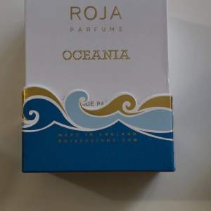 Säljer en lyxig parfym från Roja Parfums, Oceania Eau de Parfum. Förpackningen är elegant med blå och vita vågmönster och guldiga detaljer. En del av intäkterna går till välgörenhet för att skydda haven. Perfekt för den som älskar exklusiva dofter och vill bidra till en god sak.