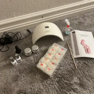 Säljer set med LED/UV-lampa, två builder-gel varav en i vit, två rosa naglar från depend gel IQ, nageltippar, top/base coat, glitter och rosewood stick för nagelbanden samt instruktionsbok!! OBS: tredje bilden du kommer inte kunna göra naglar utan clean off solution och lim åtminstone, men finns billigt att beställa🥰 det är INTE i nyskick, dvs har använt gelén osv. Men mycket kvar, skulle säga minst 70-80%. Säljer endast som kit, allt desinfekteras innan leverans. Skriv för frågor💕