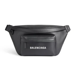 Svart axelremsväska från Balenciaga - Säljer en snygg svart axelremväska från Balenciaga. Väskan har en praktisk dragkedja och ett justerbart bälte. Perfekt för att hålla dina saker säkra och stiliga på samma gång. Den har en klassisk design med Balenciaga-loggan i vitt framtill. 