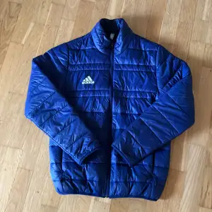 Säljer en snygg blå quiltad jacka från Adidas i storlek S. Jackan har en dragkedja framtill och är perfekt för kyligare dagar. Dem är sparsamt använda och är i nyskick! Perfekt för höst och vinter ❄️! Nypris 600 kr. Hör av er för frågor! 👀