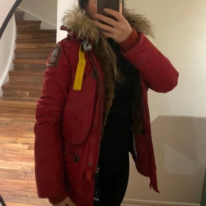 Röd vinterjacka från Parajumpers - Säljer en snygg röd vinterjacka från Parajumpers i mycket bra skick. Jackan har en pälsfodrad huva och detaljer som dragkedja och knappar. Perfekt för kalla vinterdagar! 🧥❄️ köpt för 9 999kr säljer för 999