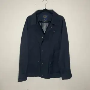 Säljer en stilren mörkblå jacka från Polo Ralph Lauren i helt nytt skick. Jackan har en klassisk design med knappar framtill och långa ärmar. Perfekt för höst och vår, och passar både till vardags och lite finare tillfällen. Skön och praktisk med fickor fram. Nypris är ca 3800kr och säljs också på eBay för 2500kr och mitt pris är bara 1799kr. Hör av dig vid intresse! 💙