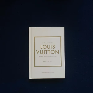 Little Book of Louis Vuitton - En stilren bok med beige omslag och gulddetaljer som berättar historien om det ikoniska modehuset Louis Vuitton. Perfekt för modeintresserade och designälskare.