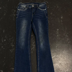 Llågmidjade bootcut jeans - Snygga mörkblå bootcut jeans med låg midja. Liten skavank på baksida lår, syns på bilden! Innerbenslängd: 77cm, midjemått 38cm