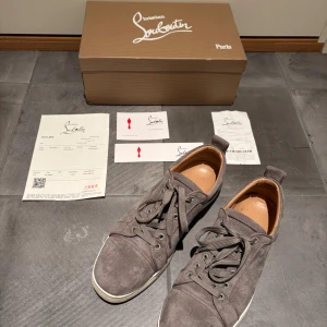 Grå mocka sneakers från Louboutin - Säljer ett par riktigt feta gråa Loubitins i storlek 43. De är ganska varma så funkar fint under vintern. Skick - 8.5/10, allt ser nytt ut förutom sulan som är lite smutsig. Låda, kvitto mm tillkommer. Skriv om du har någon fråga!