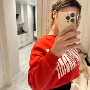 Röd sweatshirt från Champion - Säljer en cool röd sweatshirt från Champion med stort vitt tryck på framsidan. Den är perfekt för en avslappnad stil och har en normal passform. Tröjan är i mycket bra skick och passar perfekt för höst och vår. Superbekväm och lätt att matcha med jeans eller joggers! S/M/L storlek