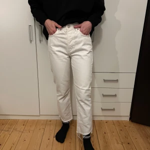 Vita jeansbyxor - Säljer ett par vita jeansbyxor i mycket bra skick. De är högmidjade och har en straight passform. Perfekta för både vår och sommar! Byxorna har en snygg, enkel design utan extra detaljer, vilket gör dem lätta att matcha med olika outfits.