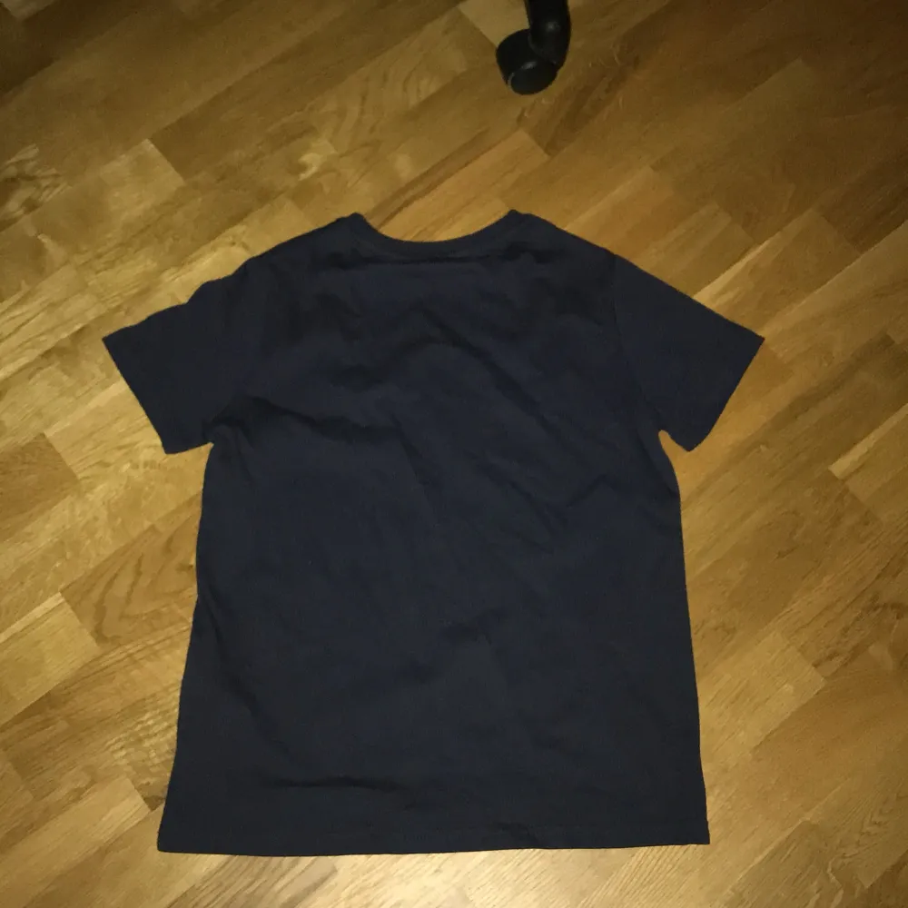 Säljer en svart t-shirt från Lyle & Scott med en liten gul logga på bröstet. Perfekt för vardagsbruk och enkel att matcha med andra plagg. Tillverkad i Turkiet.. T-shirts.