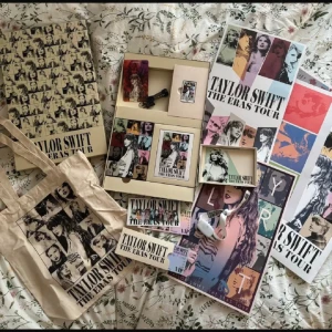 Taylor Swift The Eras Tour samlarbox - Säljer min Eras Tour VIP Box!😍 Allting på bilden är med utan armbandet. Innehåller affischer, vykort och en tygväska med olika tryck från turnén. 💚💛💜❤️💙🖤🩷🩶🧡