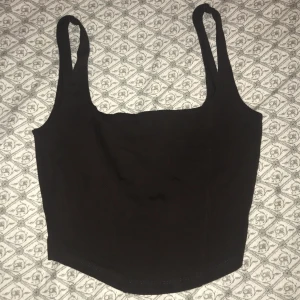 Svart linnetopp från Gina Tricot - Snygg svart linnetopp från Gina Tricot i storlek XS. Perfekt för sommardagar eller som ett basplagg i garderoben. Toppen har breda axelband och en enkel design som gör den lätt att matcha med olika outfits.