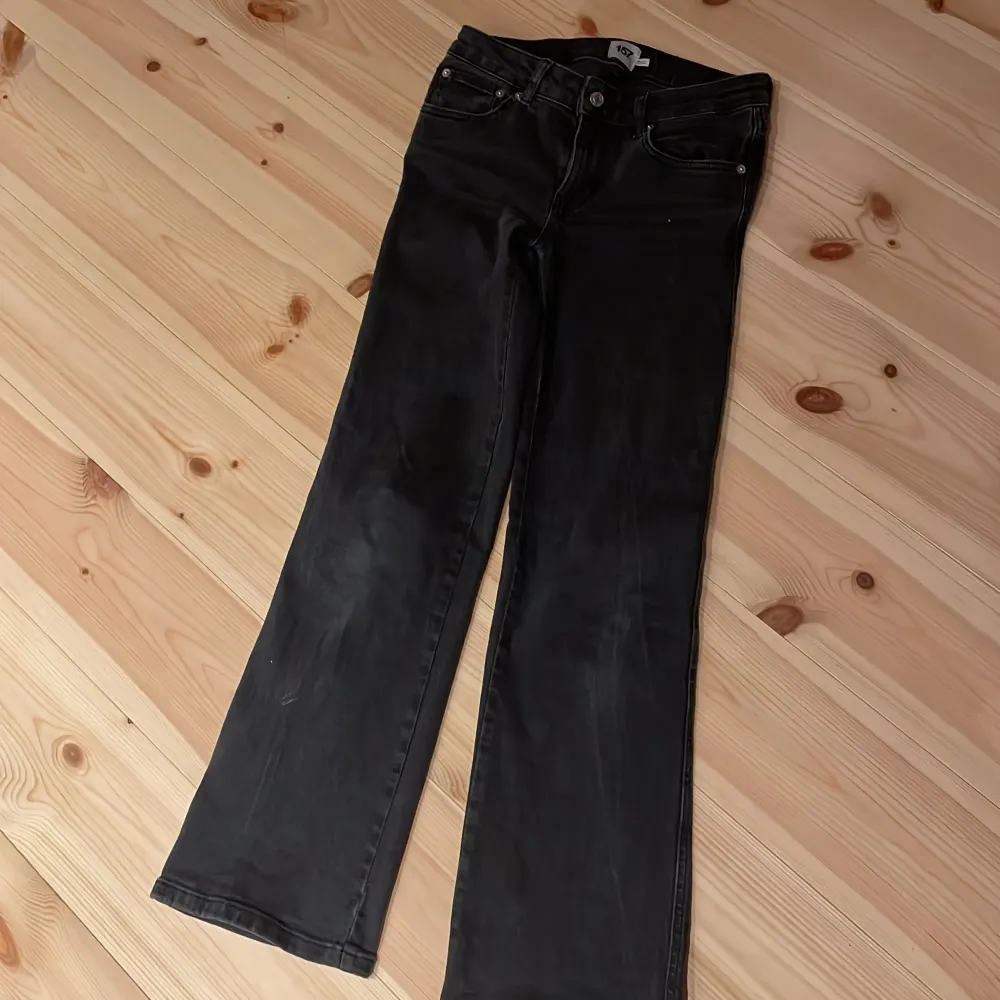 Säljer ett par svarta bootcut jeans från lager 157. De har en klassisk femficksdesign med snygga detaljer som silverfärgade knappar på bakfickorna. Perfekta för en avslappnad men stilren look!. Jeans & Byxor.