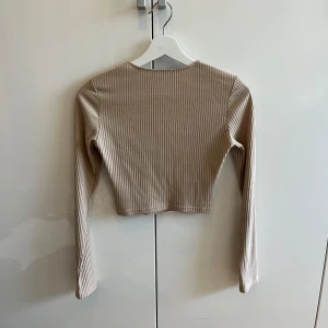 Beige topp från NAKD - Beige topp från NAKD. Sitter tajt och är lite kroppad