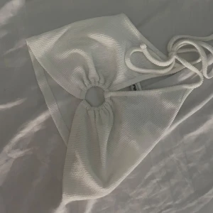 Liten h&m topp - En vit liten Top från h&m med typ en liten cirkel vid bröstet 