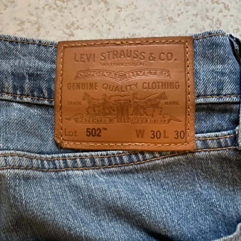 Säljer ett par blå Levis 502. De är i bra skick och sparsamt använda. De är i storlek 30/30 och straight passform. Något att notera är att färgen på de stämmer mer på bild 4 än på de andra.. Jeans & Byxor.