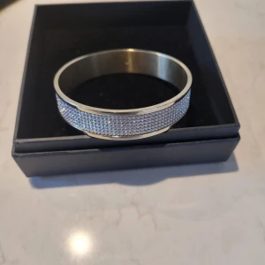 Armband - Elegant och modernt armband med guldfinish och klara vita Swarovski-kristaller som skapar en lyxig men stilren look.  Nypris ca 1400 Använd ett fåtal gånger!