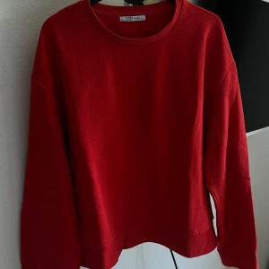 Röd tröja från Zara - Säljer en snygg röd tröja från Zara Trafaluc. Den är perfekt för både höst och vinter med sin varma och bekväma känsla. Tröjan har en klassisk rund hals och långa ärmar, vilket gör den superenkel att matcha med olika outfits. Perfekt för en casual look eller att mysa i hemma!