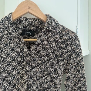 Figursydd topp  - Figursydd topp med knappar materialet är lite som virkat. 