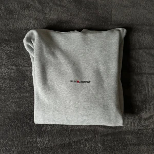 Saint Laurent Hoodie - En väldigt skön och allmänt nice grå hoodie från YSL. Bara att komma privat vid funderingar.
