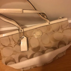 Äkta Coach väska - Superfin äkta vintage Coachväska i beige canvas. Väldigt fint skick! Köpt på Vestiare Collective! Storlek medium. 