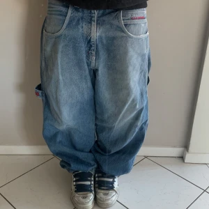 Baggy jeans med broderad detalj - Säljer ass coola vintage sancezz byxor från 90 talet🔥väldigt stora och baggy💥        En av fickorna är lite sönder från INSIDAN men påverkar inte hur byxorna ser ut!!! Pris kan diskuteras😁😁 Längd:110cm lår:32cm benöppning:22cm W34 L33🤓👆