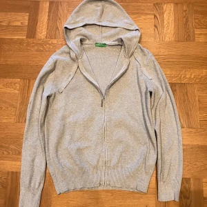 Grå hoodie - Grå hoodie från United Colors of Benetton. Säljer pga att den inte passar mig längre. Liten i storleken men passar både M och S beroende på önskad passform. Tillverkad i 100% bomull! Nypris 949kr. Skriv vid minsta fundering!
