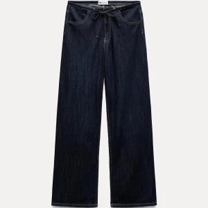 Mörkblå jeansbyxor med knytband - Snygga mörkblå jeans med knytband i midjan. Använda typ 10 ggr! Breda i modellen