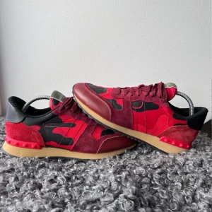 Röda Valentino Rockrunner - Snygga Valentino Rockrunner sneakers i röd och svart med ett camouflage-mönster. Skorna har snörning och en unik design med mocka och skinn detaljer. Skicka ett pm vid minsta lilla fundering! OBS!! Box & Dustbag skickas ej med. Mvh, Sami