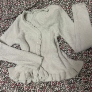 Vit topp - Vit ribbad topp med volangdetaljer. Står ej storlek men passar XS/S. 50 kr