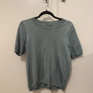 Grön kortärmad topp från Lindex - Säljer en stilren grön topp från Lindex i storlek S. Toppen är tillverkad av en blandning av lyocell och polyester, en mjuk och bekväm känsla. Den har korta ärmar och en rund halsringning. Perfekt för alla årstider. Nypris 279kr men säljs inte längre, mitt pris 150kr. Använd ungefär 20 gånger men inga synliga täcken på användning 🥰Kommer såklart nytvättad! 