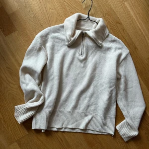 Vit stickad tröja  - Vit stickad tröja i storlek S. Finns dragkedja framtill så att man kan göra tröjan till en polotröja