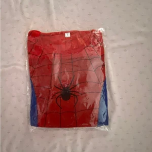 Barn Spindelmannen Dräkt I 3 Delar  - Säljer en cool röd och blå tröja med spindelmotiv och matchande huva. Perfekt för den som älskar superhjältar! Tröjan har långa ärmar och ett nätmönster som ger en autentisk look.  Stlk kvar S 2-3 år , M 4-5 år och L 6-8 år, helt ny, 155kr/paket 