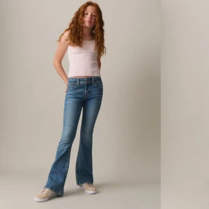 Blå bootcut jeans - Snygga blå bootcut jeans med klassisk femficksdesign och broderad detalj på bakfickorna. De är midwaist och har en bekväm passform som ger en retro känsla. Perfekta för en avslappnad stil.