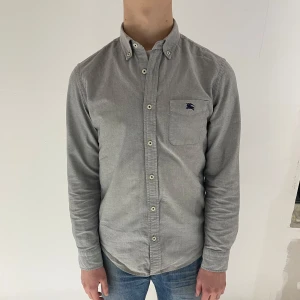 Grå skjorta från Burberry - Grå Oxford skjorta från Burberry (Black Label). Mycket fint skick, inga fel. Passar som stl S (Black Label = Japanska divisionen). Modellen är 173cm och väger 65kg. 