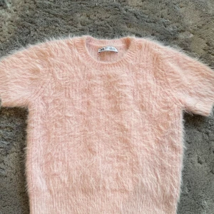 Rosa fluffig tröja från Zara - Säljer en supermjuk och fluffig rosa tröja från Zara. Perfekt för att hålla sig varm och stilren under kyliga dagar. Tröjan har korta ärmar och en rund halsringning. Ett måste för garderoben! 💖