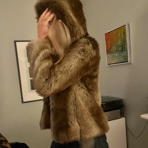 Brun pälsjacka med luva - Säljer min jättefina fuskpälsjacka från Zara. Köpt på vinted men knappt använd av mig och den är därav i väldigt bra skick😍  Perfekt nu inför våren.
