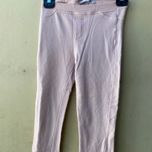 Beige leggings - Säljer ett par rosa leggings i mjukt material. De är perfekta för en avslappnad stil och har en bekväm passform. Perfekta för vardagsbruk!