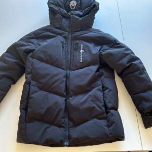 Säljer en svart pufferjacka i nyskick från Sail Racing JR patrol down jacket i storlek 150. Jackan är både vind- och vattenavvisande. Nypris 3199 på Kids brandstore. Säljer för 2000:-