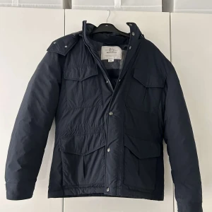 Woolrich Vinterjacka‼️ - 2 små defekter på nedre höger fickan. Modellen på bilden är 187 cm lång. Nypris på runt 7 tusen kr. Luvan går även att ta bort så att det blir en field jacket. Pris kan diskuteras. Inga retur.